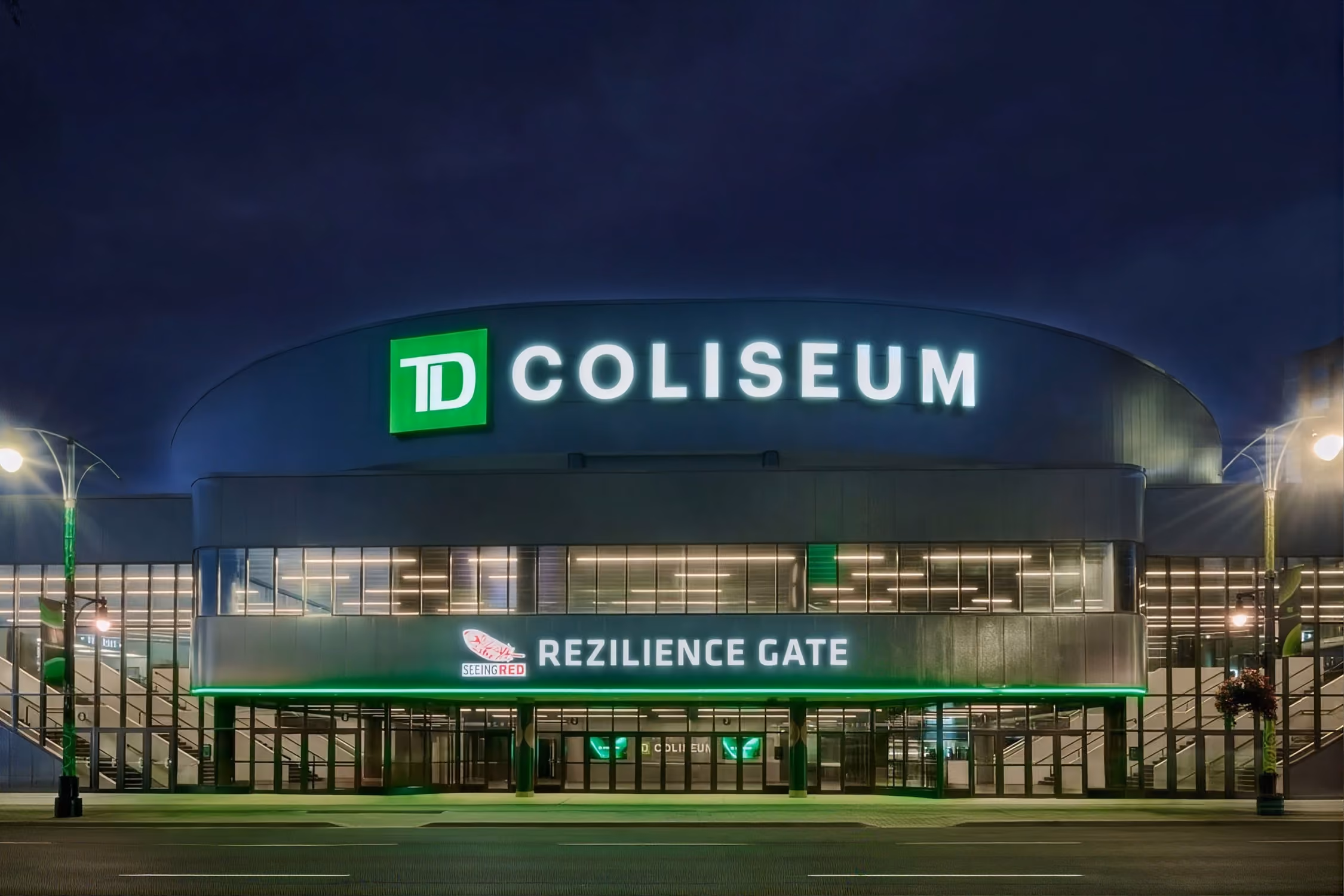 The TD Coliseum at night, its green sign lit above the Rezilience Gate entrance.