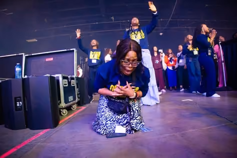 A worshipper kneeling at the front of the stage.